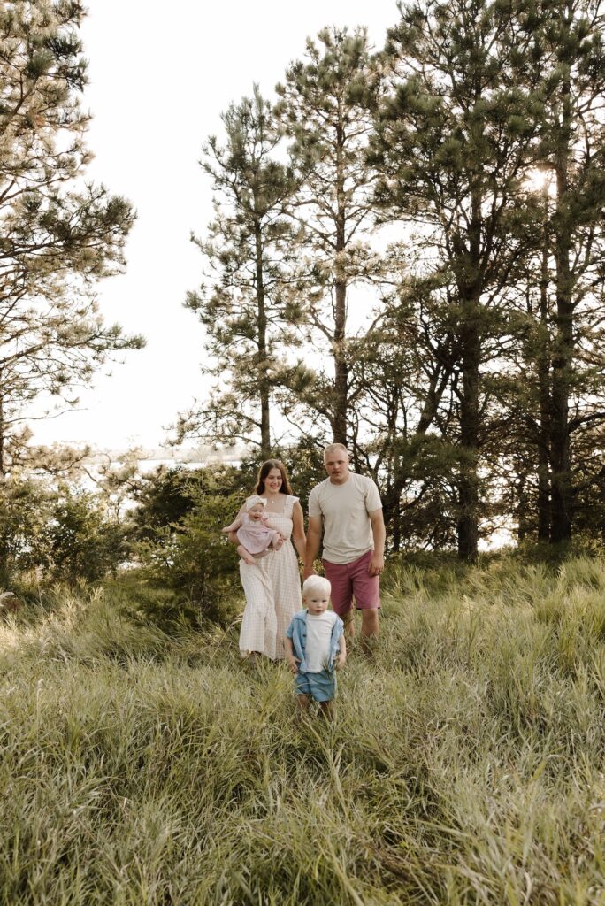 a family of 4 walking causally through the grass during their family photoshoot
