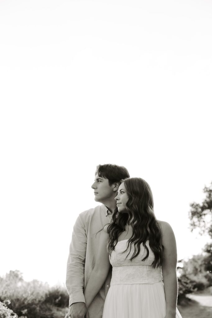 couple standing next to each other, and both looking into the distance