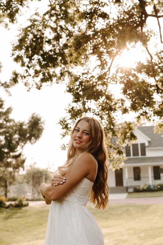 senior girl posing for a photographer in a feild