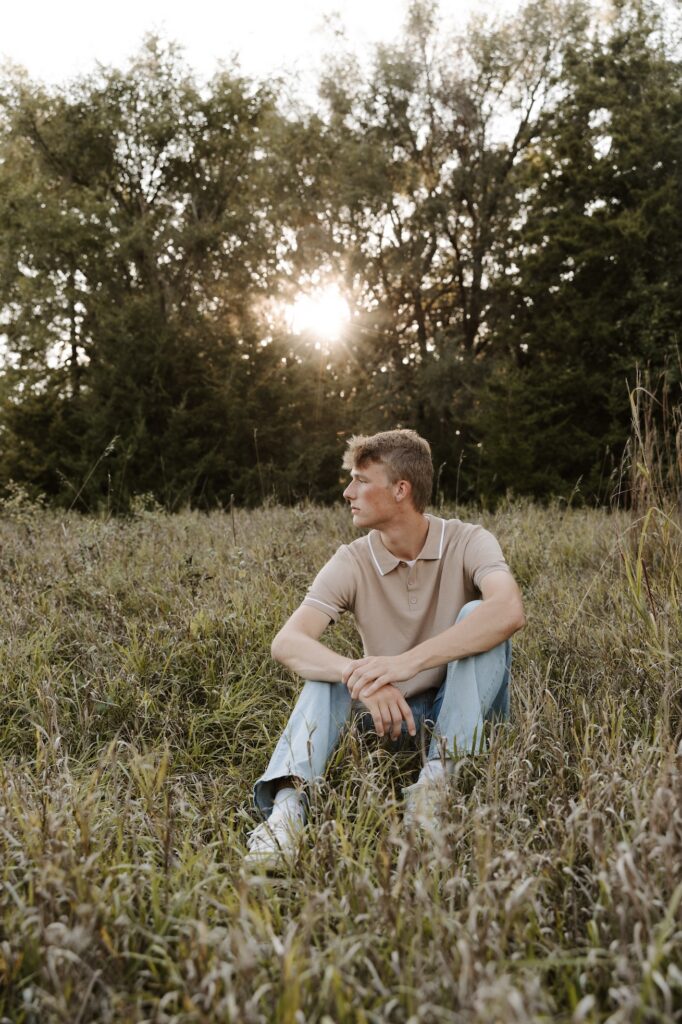 senior posing for a picture, squatted down look off to the side