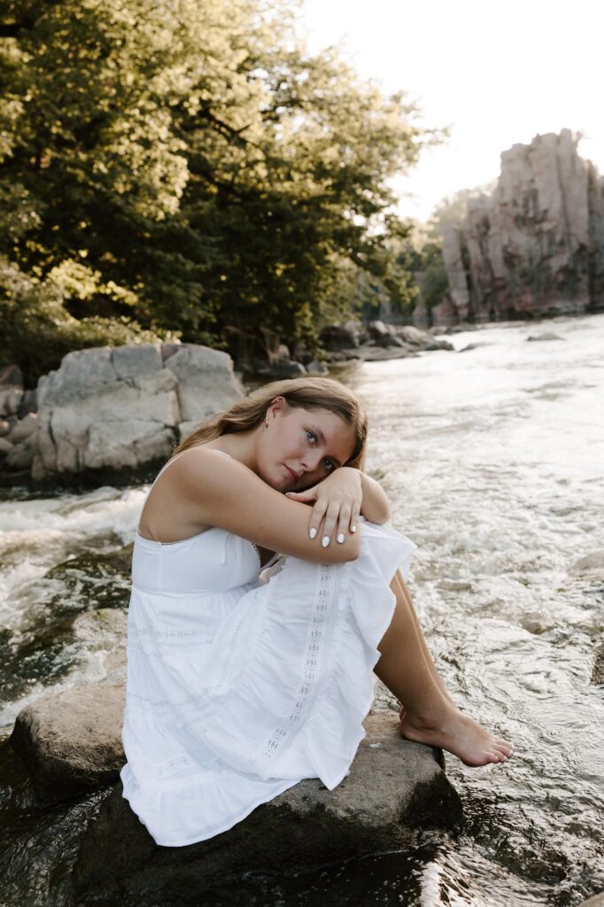senior girl posing for a photographer in a feild