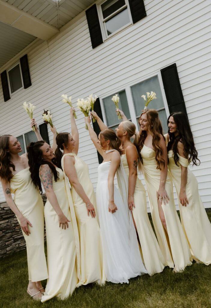 bridesmaids photo with them raising their bouquets in the air