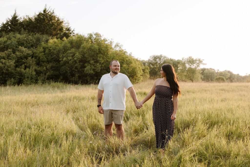 couple posing for a camera as a photographer takes their photo